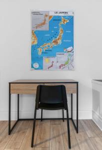a black chair sitting in front of a desk with a map at L'Annexe Gannat - Appartements en centre ville in Gannat