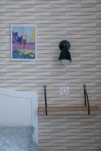 ściana z lampką i ławką w pokoju w obiekcie L'Annexe Gannat - Appartements en centre ville w mieście Gannat