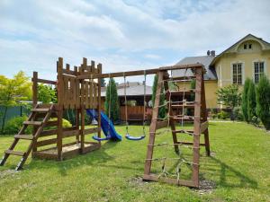 a wooden playground with a swing set in a yard at Vila Liduška 