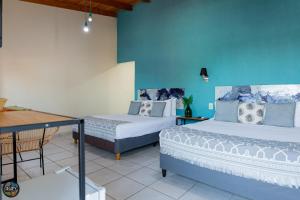 a room with two beds and a blue wall at Arapy Bed and Dream in Puerto Iguazú