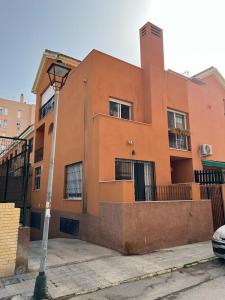 un bâtiment orange avec une lumière de rue devant lui dans l'établissement Ameyal Casa PIO XII, à Sanlúcar de Barrameda