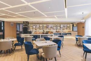 a restaurant with tables and chairs and a kitchen at Atour Hotel Jiading Jiangqiao Jiayi Road Subway Station in Fengbang