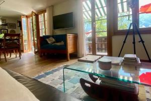 a living room with a glass table and a couch at Chalet Tannegüetli in Grindelwald