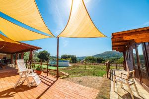 eine Terrasse mit 2 Stühlen und einem großen Sonnenschirm in der Unterkunft La Mantecata b&b in Itri