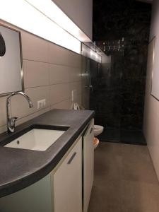 a bathroom with a sink and a shower with a toilet at La pietra lavica in Linguaglossa