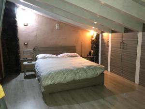 a bedroom with a large bed with a wooden floor at La pietra lavica in Linguaglossa