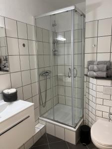 uma cabina de duche em vidro numa casa de banho com WC em Apartment Falg em Goslar