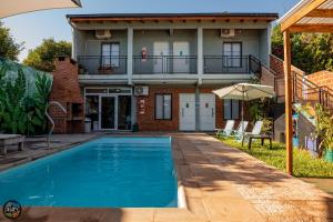 a house with a swimming pool in front of a house at Arapy Bed and Dream in Puerto Iguazú