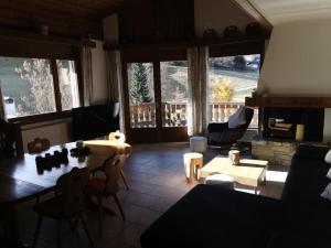 een woonkamer met een bank en een tafel bij Ferienwohnung im Haus Soldanella in Obersaxen