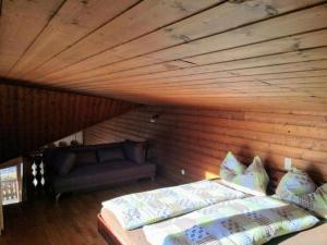 a bedroom with a bed and a couch in a room at Ferienwohnung im Haus Soldanella in Obersaxen