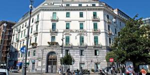 duży biały budynek na rogu ulicy w obiekcie Hotel Plaza w mieście Salerno