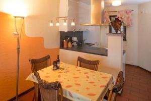 a kitchen with a table with chairs and a dining room at Residenza Viramonte - Casa Bianca, Wohnung 15 in Vira