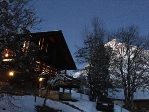 una cabaña en la nieve por la noche con una montaña en alleinstehendes Ferienhaus en Grindelwald