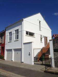 un edificio bianco con due porte garage su una strada di 'Hidden Jewel' city centre + FREE PARKING a Plymouth
