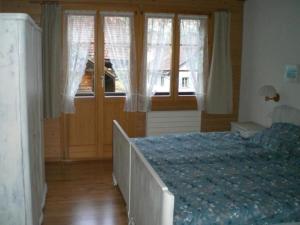 een slaapkamer met een bed en een raam met gordijnen bij Ferienwohnung "Margrit Ost" in Lauterbrunnen