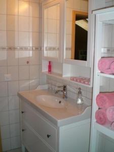 een badkamer met een wastafel, een spiegel en roze handdoeken bij Ferienwohnung "Margrit Ost" in Lauterbrunnen