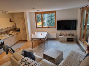 een woonkamer met een bank en een tafel bij Forest View, 2-floor Apartment in Hočko Pohorje