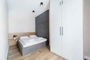 ein kleines Schlafzimmer mit einem Bett und einem Schrank in der Unterkunft Krakowiak Apartment in Krakau