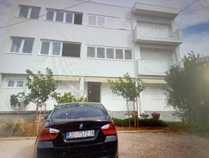 a black car parked in front of a house at Apartmani Trubi in Vodice