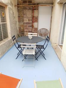 een tafel en stoelen op een patio bij Joli duplex calme avec terrasse centre Paimpol in Paimpol