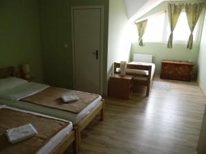 Habitación con 2 camas, silla y ventana en B&B Majhen, en Kopačevo