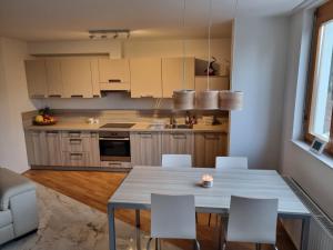 a kitchen with a table and chairs in a room at Forest View, 2-floor Apartment in Hočko Pohorje