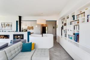 uma sala de estar com um sofá branco e estantes em Garden Seaside Villa by CadenzaLux em Cascais