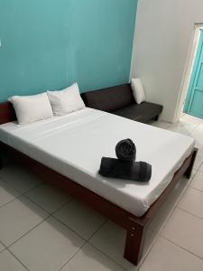 Una cama en una habitación con una toalla negra. en Tourquesa Excellent WiFi Private en Liberia