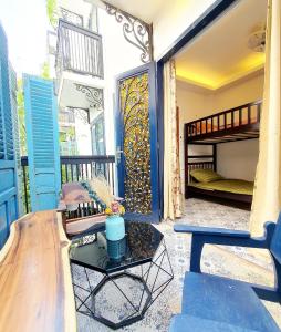 Zimmer mit einem Balkon, einem Bett und einem Tisch in der Unterkunft The Lovenote Home in Ho-Chi-Minh-Stadt
