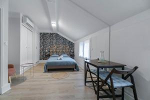a bedroom with a bed and a table and a chair at L'Annexe Gannat - Appartements en centre ville in Gannat