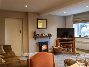 a living room with a fireplace and a television at Stork Cottage in Conder Green