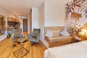 a bedroom with a bed and two chairs and a table at Luxus Apartments Mosel-Zeit NEU 2023 in Zell an der Mosel