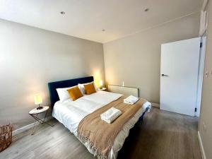 a bedroom with a large bed with two pillows on it at Sienna's 2 - bedroom apartment, London, N1. in London