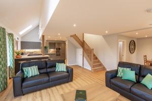 a living room with two leather couches and a kitchen at Lord Galloway 39 with Hot Tub in Newton Stewart