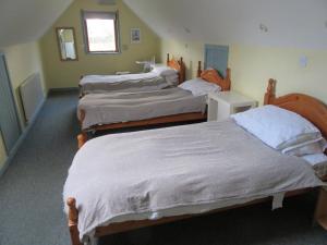 a group of three beds in a room at Osprey, Longhouse Cottages in Rosemarkie