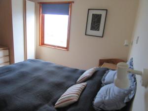a bedroom with a bed and a window at Osprey, Longhouse Cottages in Rosemarkie