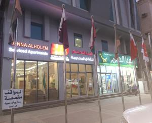 un grupo de banderas frente a un edificio en Hona Al Holm Furnished Units, en Dammam