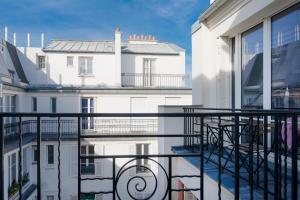 Elle comprend un balcon offrant une vue sur un bâtiment blanc. dans l'établissement Courcelles Design Duplex, à Paris