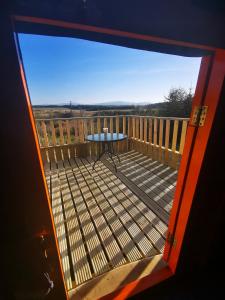 a view of a balcony with a table on a deck at The Yurt in Newton Stewart