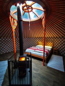 a room with a stove with a bed in it at The Yurt in Newton Stewart