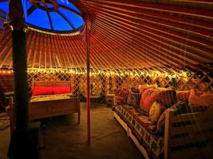 a room with a yurt with a couch and a window at The Yurt in Newton Stewart