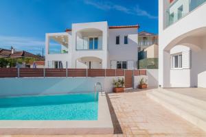 a villa with a swimming pool and a house at Astarte Villas - Ocean Pool Villa in Tsilivi