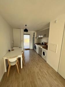 uma cozinha e sala de jantar com mesa e cadeiras em Modern and bright apartment near Paris em La Courneuve