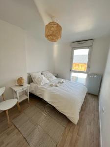 a bedroom with a bed and a table and a window at Modern and bright apartment near Paris in La Courneuve