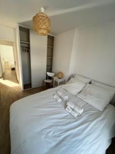 a white bed with two towels on top of it at Modern and bright apartment near Paris in La Courneuve