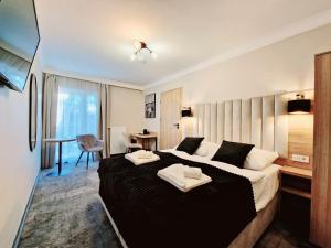 a hotel room with a large bed and a desk at Villa Cristal in Świnoujście