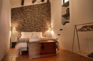 1 dormitorio con cama y pared de ladrillo en Monte Alecrim en Alandroal