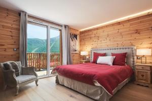 1 dormitorio con cama y ventana grande en Luxueux chalet avec terrasse Auron, en Saint-Étienne-de-Tinée