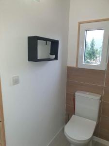 La salle de bains est pourvue de toilettes et d'une télévision murale. dans l'établissement La cabane du Mas gnolia, à Saint-Jean-du-Gard