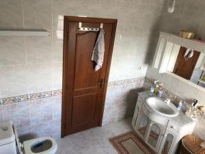 baño con aseo, lavabo y puerta en Casa da Avó Judite, en Óbidos